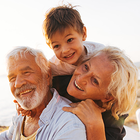 grandparents with grandson on the beach