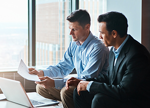 two business men discussing a document