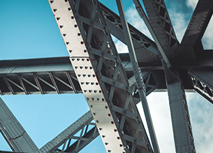 looking up at the steel beams of a bridge alone