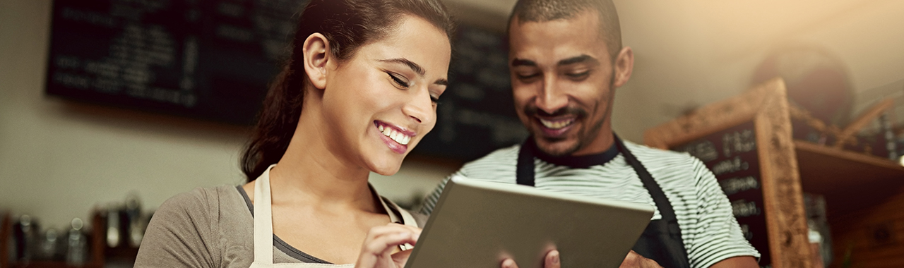 two baristas looking at an iPad