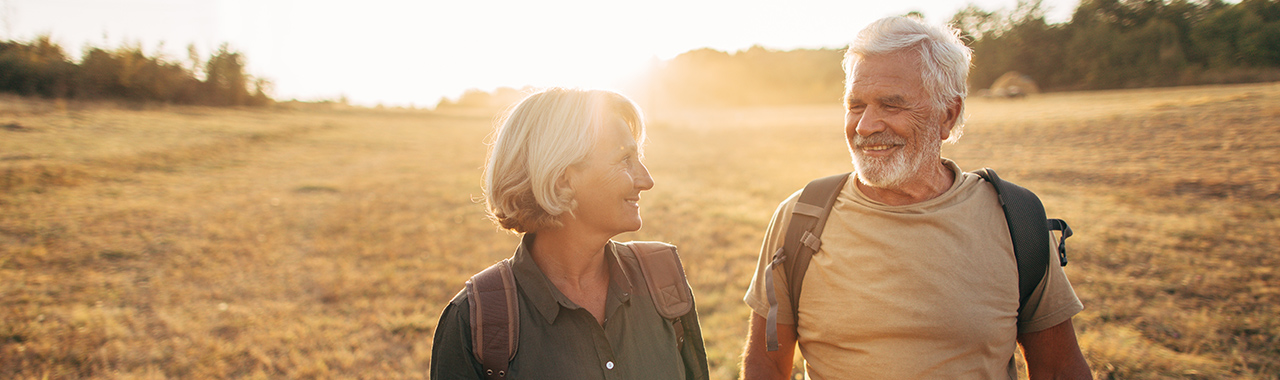 old couple walking in an open field