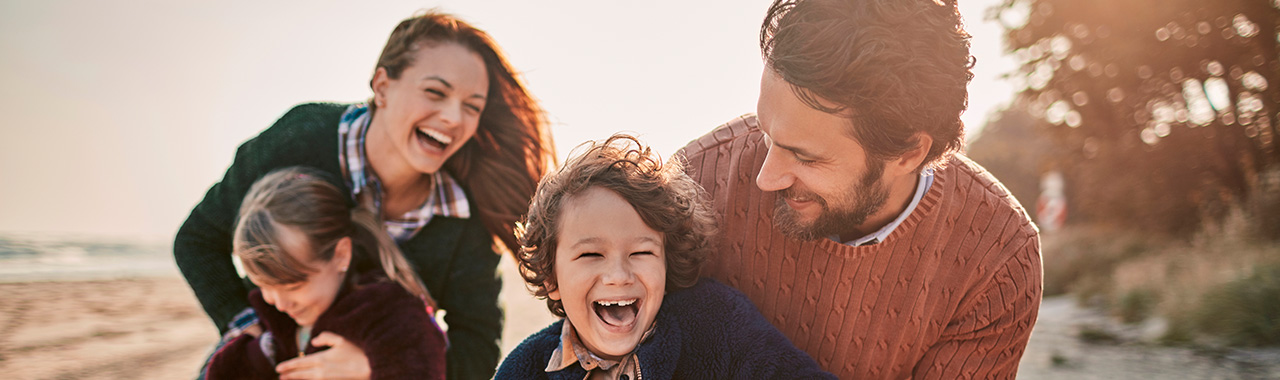 parents with their children on a beach playing