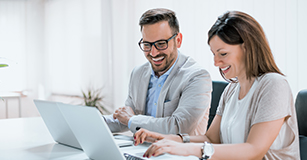 man and woman working on laptop