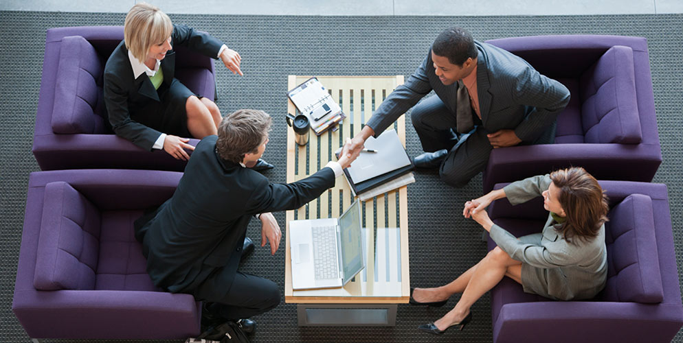 business people sitting in purple chairs