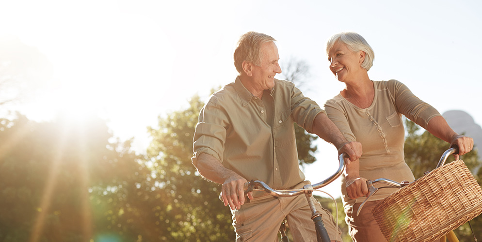 Mature couple looking at each on bicycles