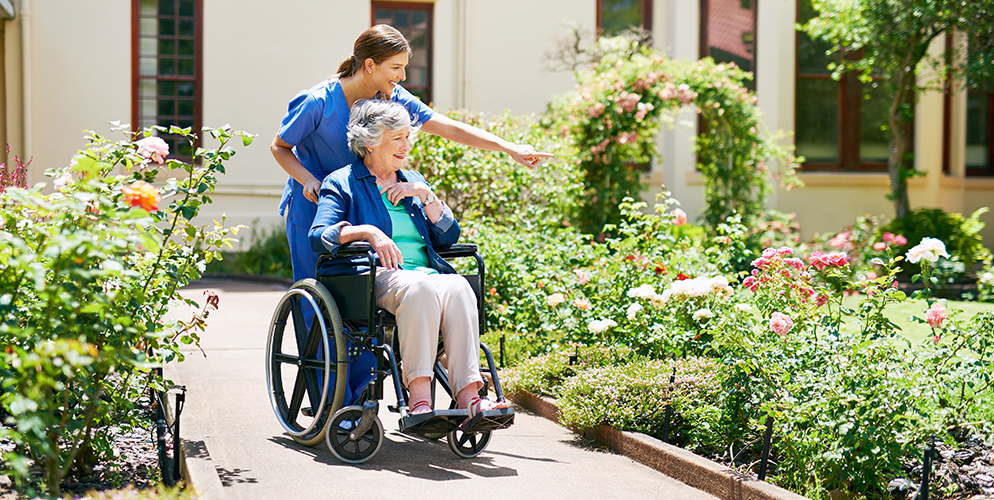caregiver pushing elderly woman
