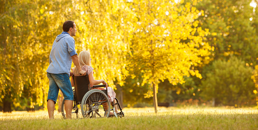 young man pushing elderly woman in wheelchair