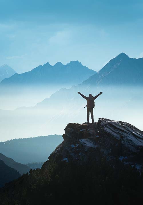 Person standing on top of the mountain