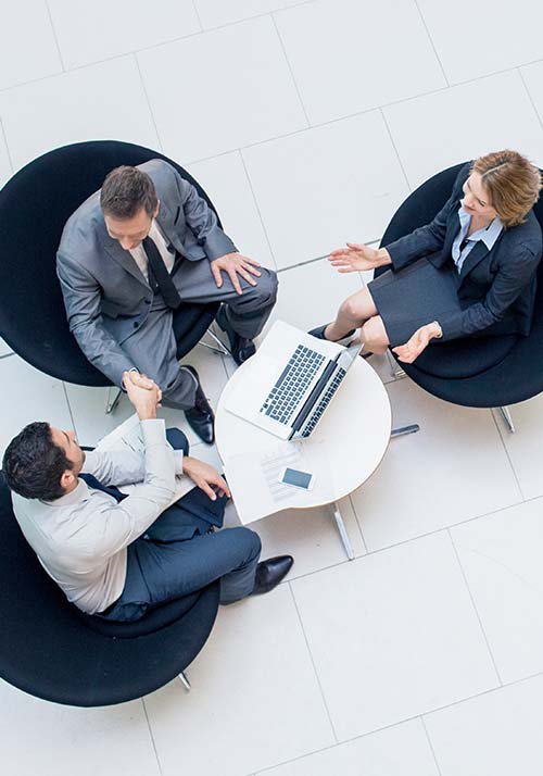 3 business people sitting around a table